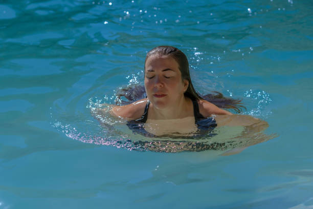 istock long-haired brunette woman bathing in a lake 1412138756