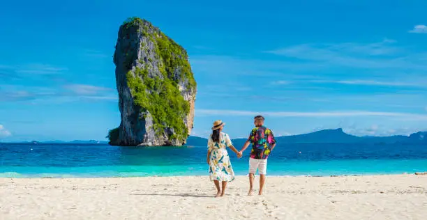 Photo of Koh Poda Krabi Thailand, Asian woman and European men walking on the tropical beach of Koh Poda