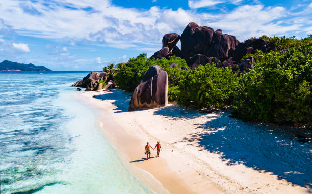 istock Anse Source d'Argent, La Digue Seychelles, young couple men and woman on a tropical beach during a luxury vacation in the Seychelles. Tropical beach Anse Source d'Argent, La Digue Seychelles 1412139876