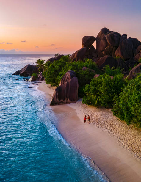 Anse Source d'Argent, La Digue Seychelles, young couple men and woman on a tropical beach during a luxury vacation in the Seychelles. Tropical beach Anse Source d'Argent, La Digue Seychelles stock photo