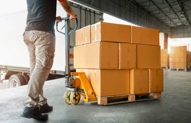 istock Workers Unloading Packaging Boxes on Pallet in Warehouse. Cartons, Cardboard Boxes. Shipping Warehouse. Shipment Boxes. Storehouse. Cargo Supplies Warehouse Logistics. 1412140386