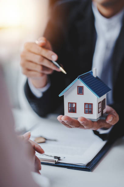 agent immobilier livraison d’échantillons de maisons aux clients, contrats de prêt hypothécaire. conclure un contrat de location-vente et de vente d’une maison. et les contrats d’assurance habitation, les concepts de prêt hypothécaire - real estate investment real estate agent real estate office photos et images de collection