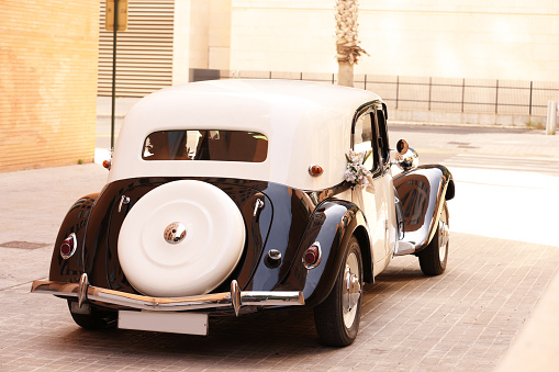 An old classic car sitting in the street