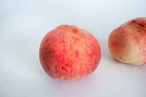 Stock photo showing close-up, elevated view of a cardboard box containing some freshly picked, ripe red / purple and yellow colour Victoria plums (Prunus domestica 'Victoria') that are for sale in a fruit and vegetable department of a green grocer's / supermarket / healthy fruit market stall.
