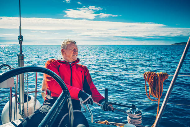 istock Sailing crew member trimming genoa sail on sailboat 1412145577