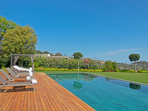 istock Deck chairs on Wooden plank floor against swimming pool 1412147249