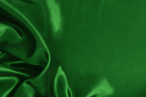 Dark green fabric cloth texture for background and design art work, beautiful crumpled pattern of silk or linen.