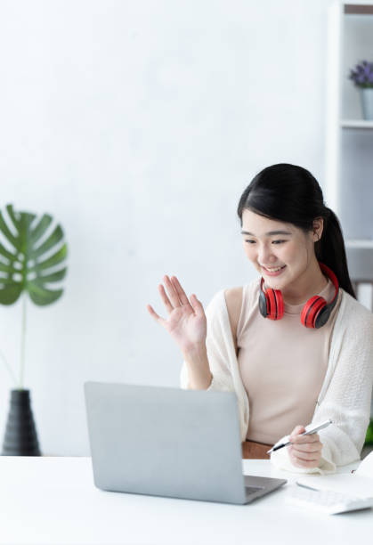 istock Education online learning or self study concept. young asian girl do researching and finding from books and internet online. 1412149657