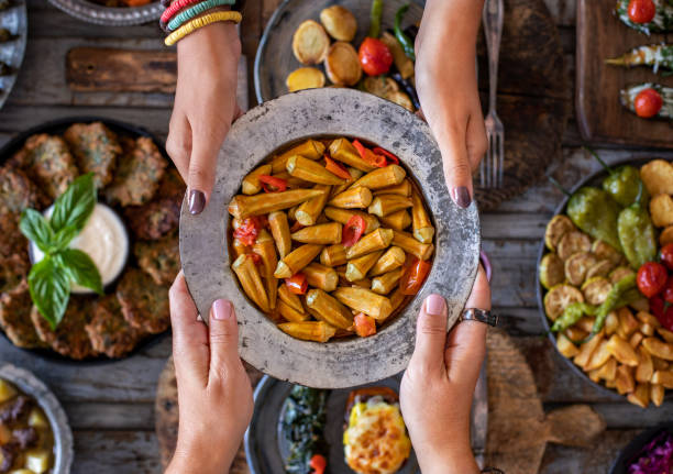Okra in the copper bowl at the hands of two women. Sıra gecesi . Healty vegan food with many vitamins. hari raya family stock pictures, royalty-free photos & images