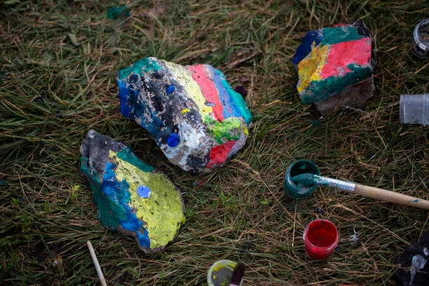 Children's master class painting with gouache on stones. Children paint on stones with brushes. High quality photo