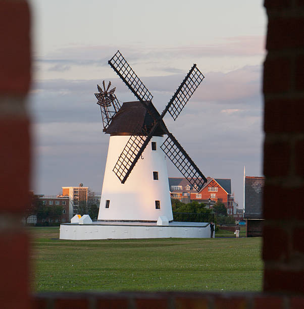 Lytham Windmill in evening light, framed by brick arch Lytham Windmill, on the Green, viewed through a brick arch at the parish church.  Evening light. lytham st. annes stock pictures, royalty-free photos & images