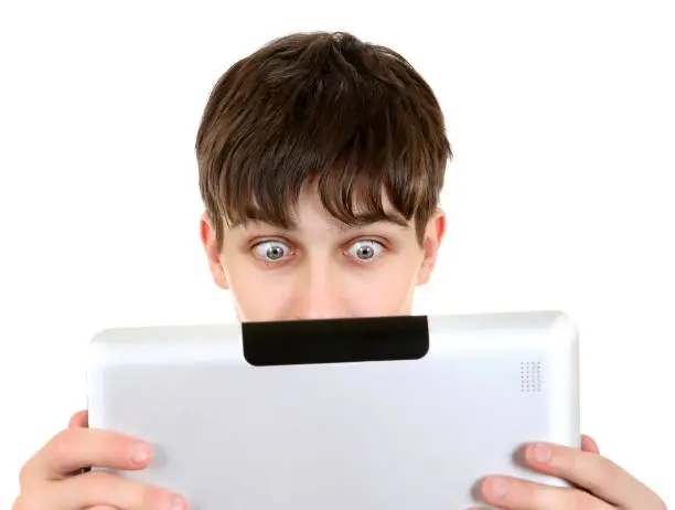 Surprised Teenager with Tablet Computer Isolated on the White Background