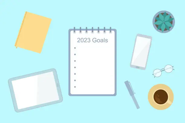 Vector illustration of Goals For 2023 Year. Top View Of Table Workspace With Notepad, Smartphone, Digital Tablet And Coffee Cup