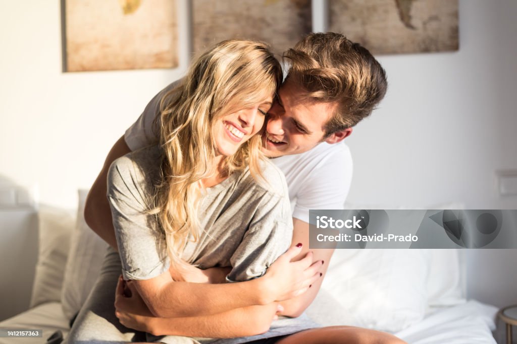 happy young couple relaxed at home on bed Love - Emotion Stock Photo