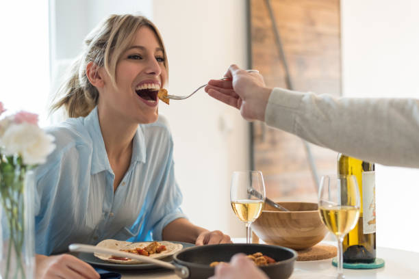 istock happy young couple having dinner at home 1412157412