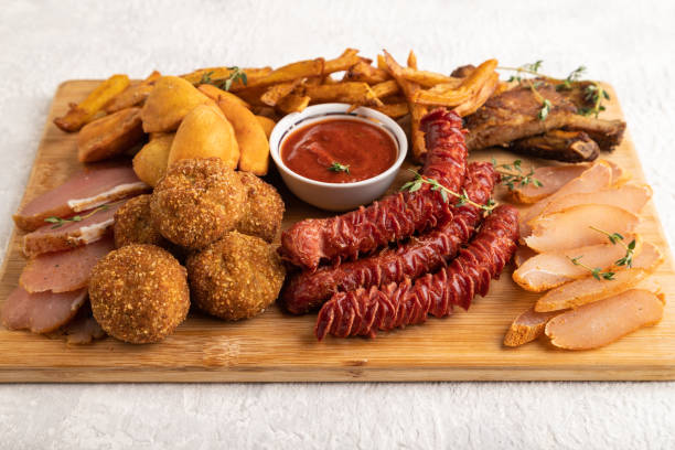 istock set of snacks: sausages, fried potatoes, meat balls, dumplings, basturma. Side view, copy space. 1412158912