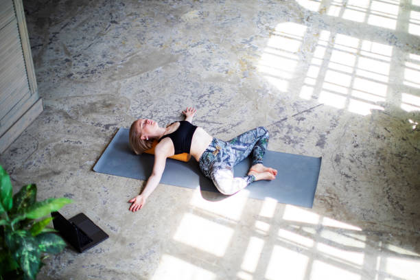 istock Young woman practicing yoga with laptop 1412159662