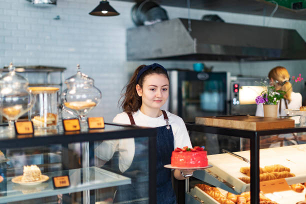 Baker taking strawberry cake from store counter