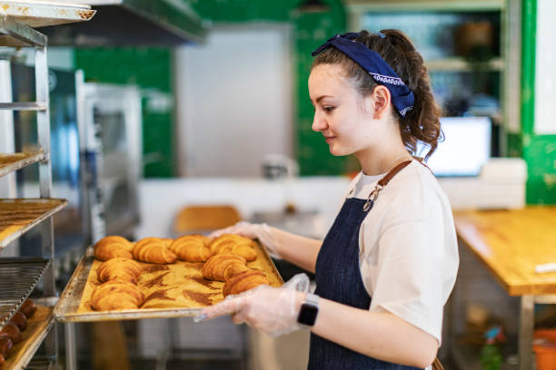 istock Baker putting buns to cooling rack for cooling after oven 1412162025