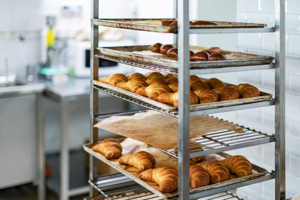 istock Fresh croissant cooling rack in pastry factory 1412162535