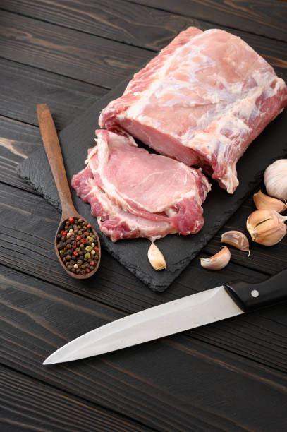 istock A large piece of pork loin on a rustic dark background. 1412163288