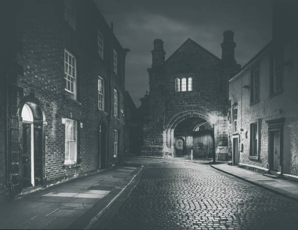Abbey Gatehouse in Carlisle seen from the cobbled road of Abbey Street on an atmospheric morning.