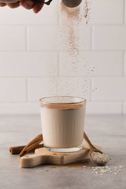 istock Cinnamon powder is poured into a glass with a cold drink based on Horchata rice. 1412163897