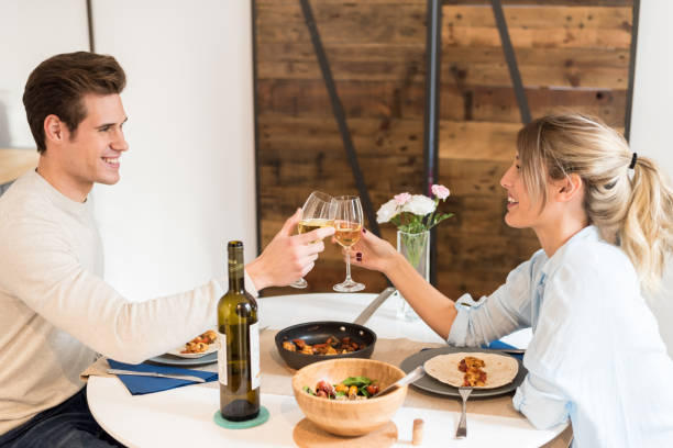 istock couple toasting with wine and havving dinner 1412166307