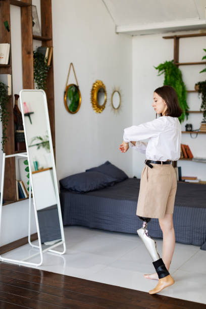 istock Young woman amputee with prosthesis trying on clothes 1412166593