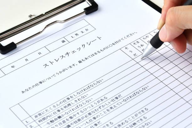 istock Business man's hand writing on stress chekcing sheet in Japanese 1412168111