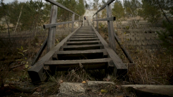 Dark figure on the old concrete stairs in the descent to the basement. Horror movie concept.