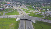 Aerial view of a freeway intersection. Clip. Highway and overpass with cars and trucks, interchange, two-level road junction in the big city. Top view.