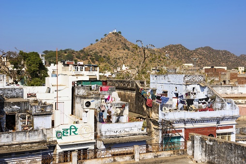 Pushkar, India, December 3, 2015: View of the roofs in the holy city of Pushkar. On the hill left is the Gayatri Mata Temple (Gayatri Mata mandir). Pushkar with 21 thousand inhabitants in the Indian state of Rajasthan is a pilgrimage site for Hindus and Sikhs.