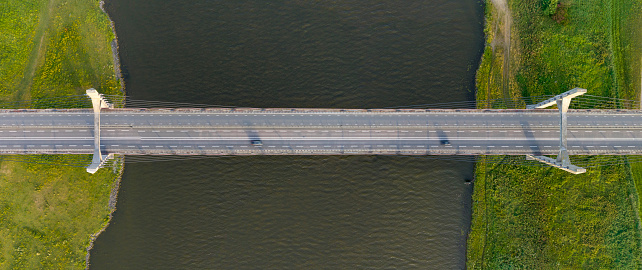 Molenbrug suspension bridge over the river IJssel near Kampen in Overijssel during a summer evening. Drone point of view from above.