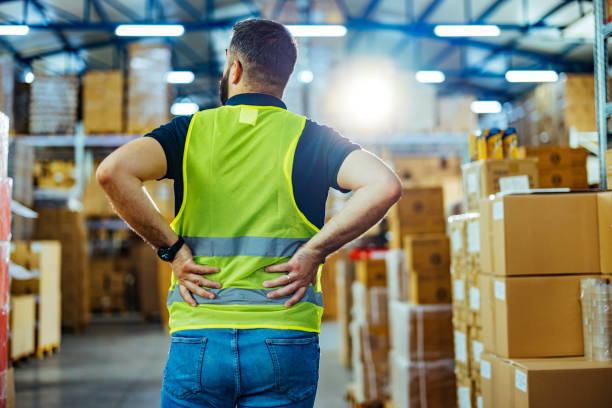 istock Rear view of male warehouse worker having back pain from hard work 1412175894