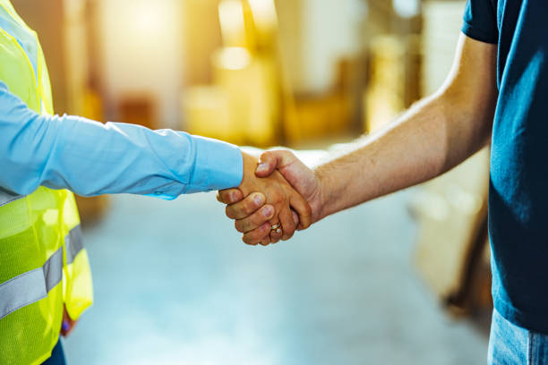 istock Photo of a warehouse manager shaking hands with worker 1412176274