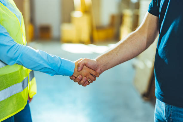 istock Businessman having a handshake with warehouse worker in logistics warehouse 1412176314