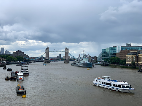 view of tames river in a cloudy day with the Tower Bridge in the background. View from London Bridge. City of London.