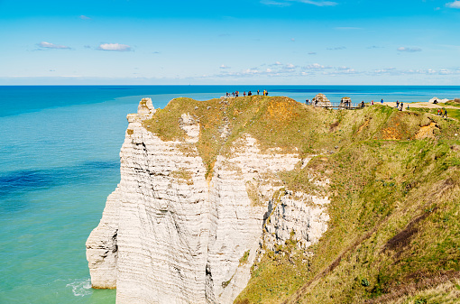 Tourists relaxing on the cliffs near the village of Etretat in the Seine Maritime Department of France.