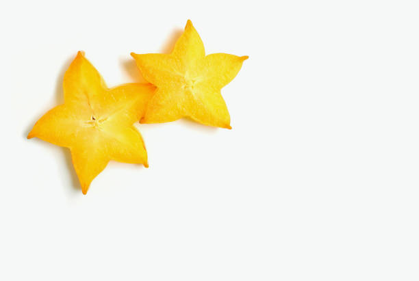 un par de jugosas rodajas de starfruit fresca madura sobre fondo blanco - carambola o carambola averrhoa carambola en el árbol fotografías e imágenes de stock
