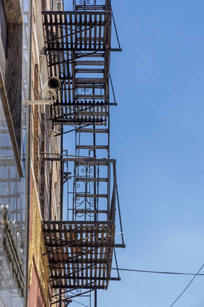 Classic American outdoor fire escape and a security camera from the corner of Broadway and 21st Street in Queens