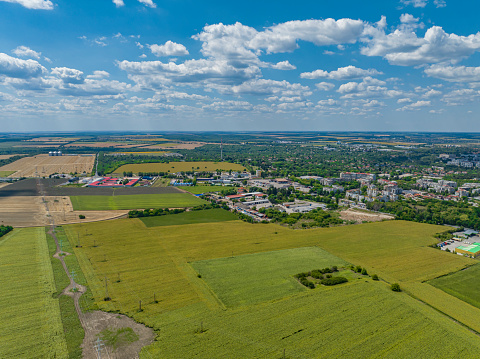 Drone point of view of TV tower in Dobrich, Bulgaria, agricultural fields, blue sky and cloudscape (Bulgarian: Град Добрич, България). The scene is situated in Dobrich, Bulgaria and is taken with DJI qudracopter Mavic III