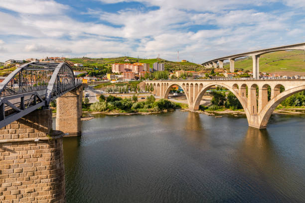 A steel bridge for pedestrians and two bridges for traffic cross the Douro River at Peso da Regua, Portugal stock photo