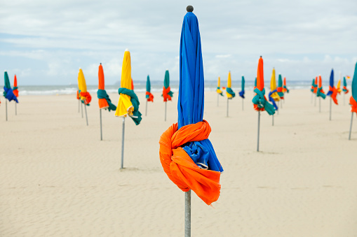 Folded beach umbrellas on the beach of Deauville, France