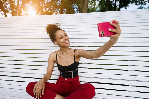 istock Girl sitting on a bench and having a video chat through phone 1412188088