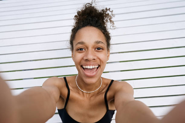 istock Woman sitting on bench and taking selfie 1412188661