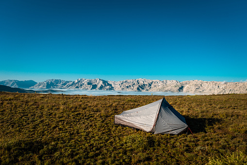 Mountainous region at high altitudes. The clouds have settled down. Gray tent alone in the meadow. Nature landscape. Mediterranean region Antalya, Taurus mountains