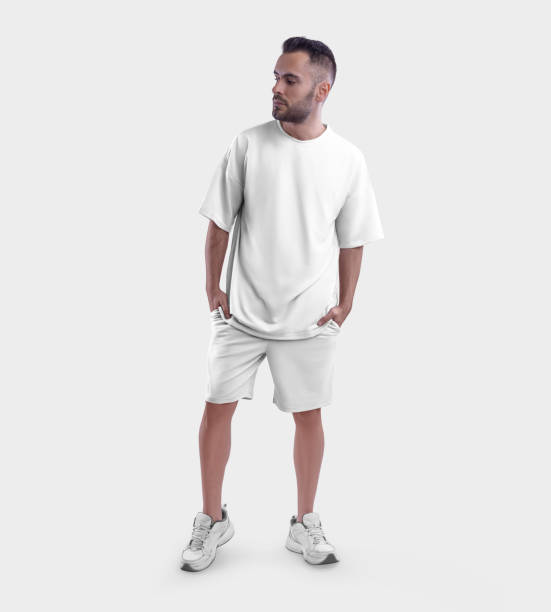 istock Oversized white t-shirt mockup, shorts on bearded guy in sneakers, with hands in pockets, front view, isolated on background. 1412189939