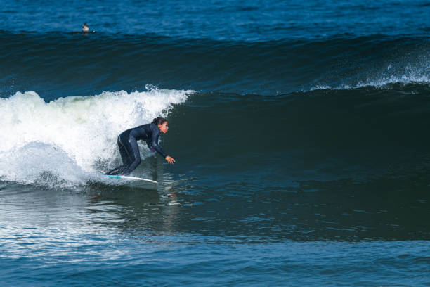 istock Female surfer riding a wave 1412191822