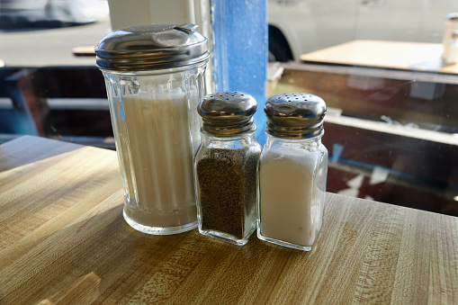 Closeup of sugar, salt and pepper shakers at a local diner